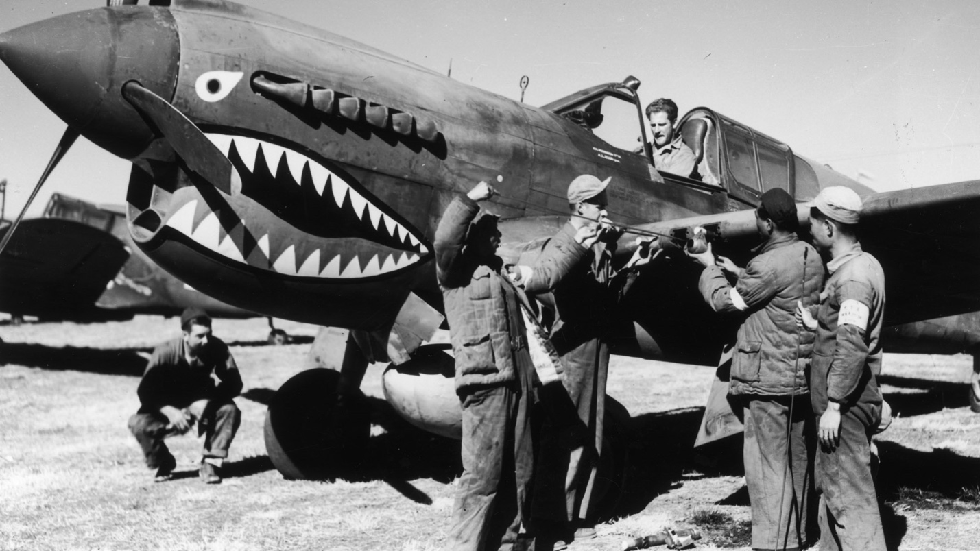 A group of men standing next to a plane

Description automatically generated
