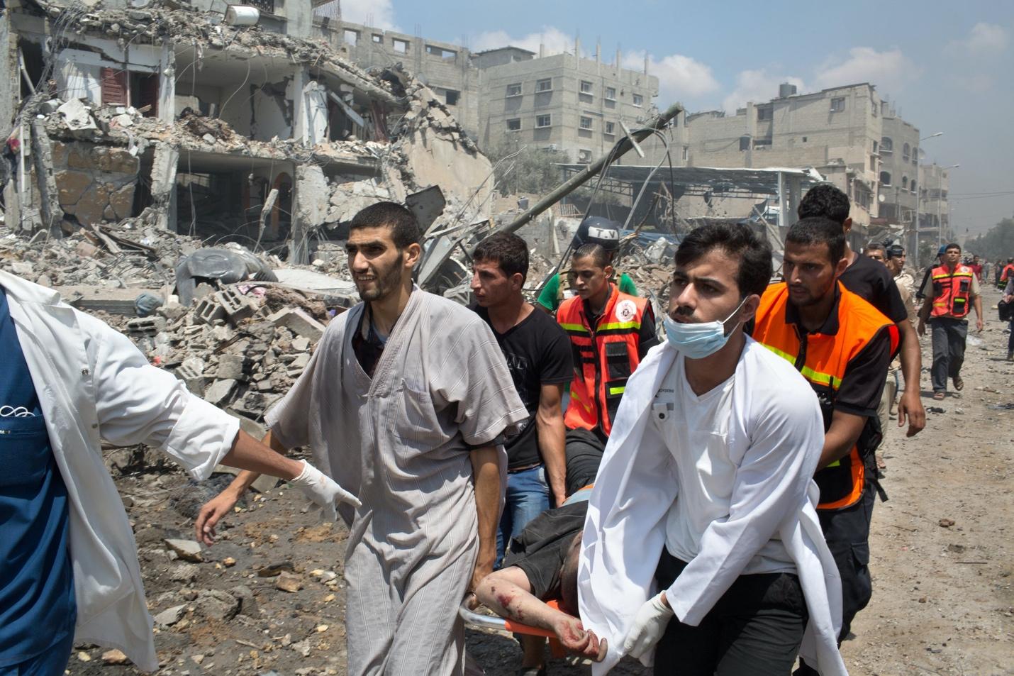 A group of people walking in a destroyed building

Description automatically generated