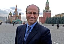 How a Billionaire Con Man Has Been a Key Driver Behind the Barrage of Anti-Russian Propaganda that Could Lead Us Into World War III A person in a suit and tie Description automatically generated