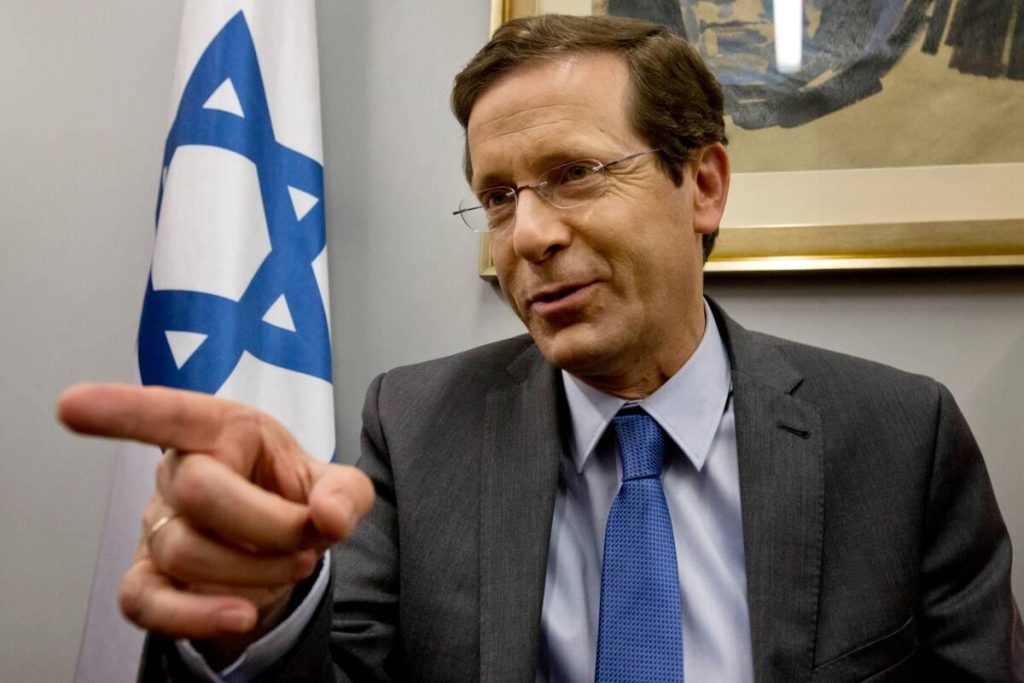 A person in a suit pointing his finger

Description automatically generated