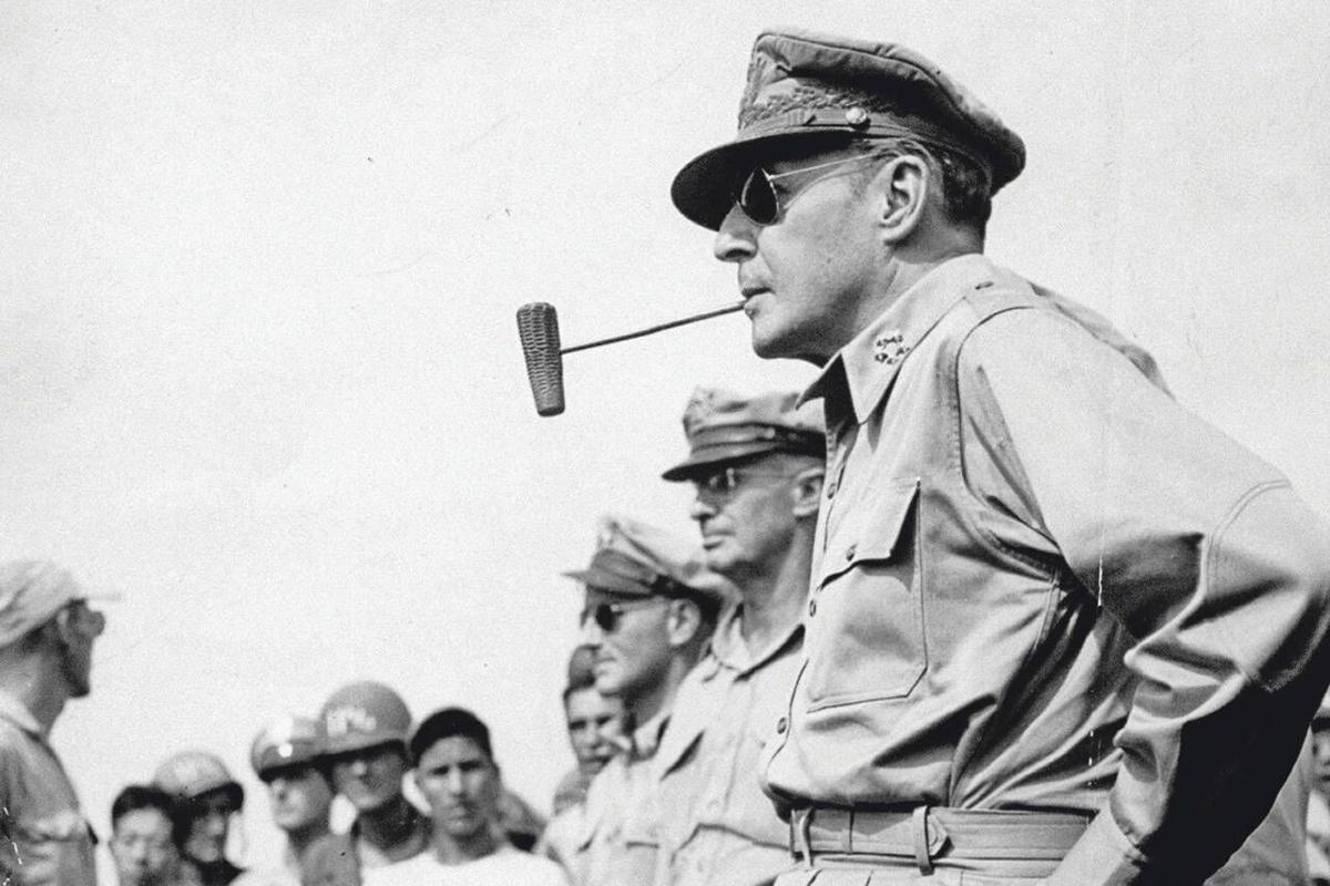 A person in uniform with a pipe in his mouth

Description automatically generated