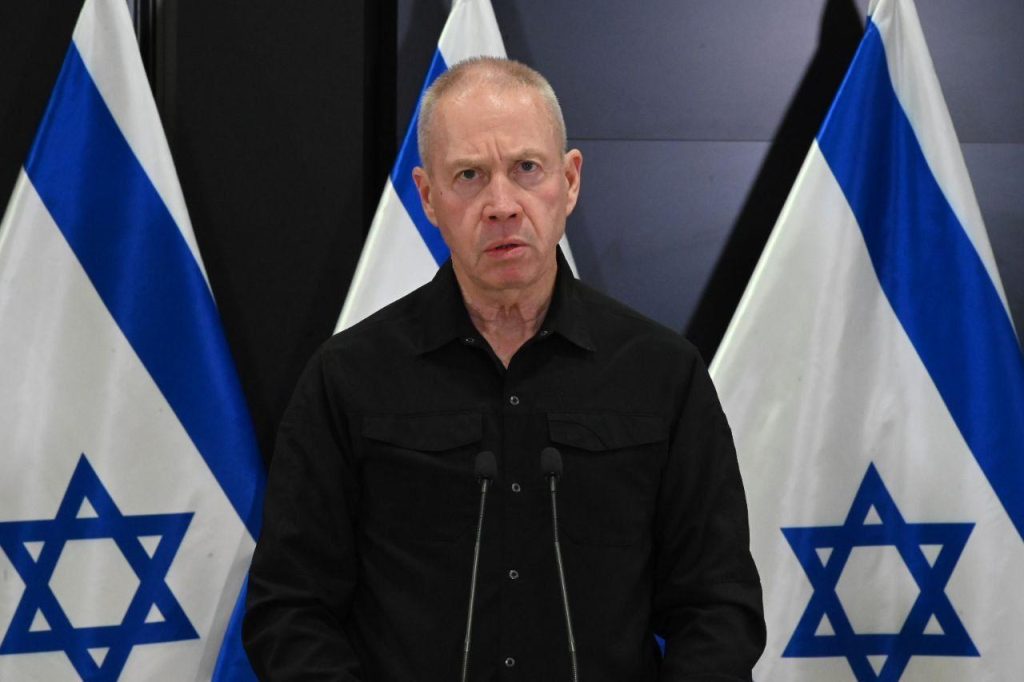 A person standing in front of flags

Description automatically generated