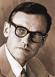 A person wearing glasses and a suit

Description automatically generated