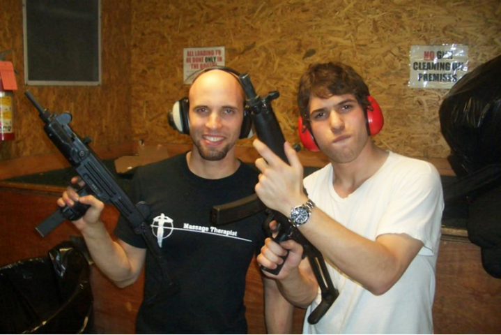 A couple of men holding guns

Description automatically generated