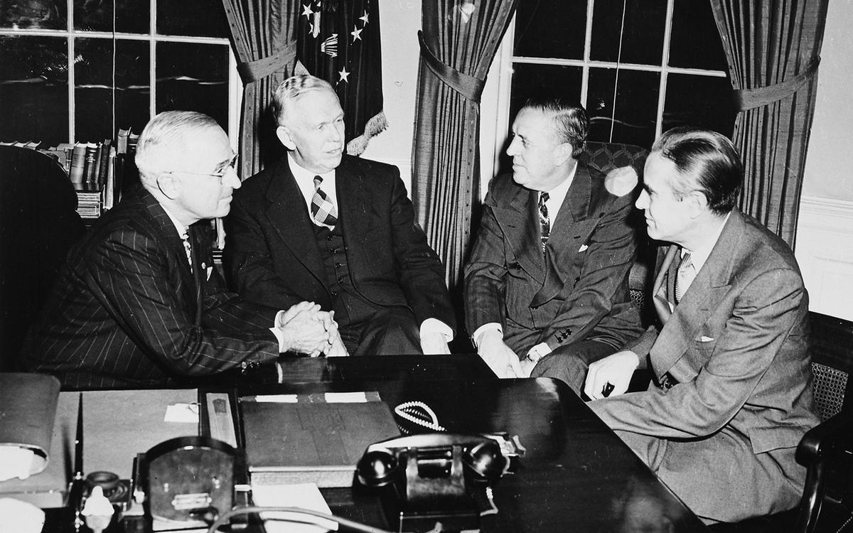 A group of men sitting at a table
Description automatically generated