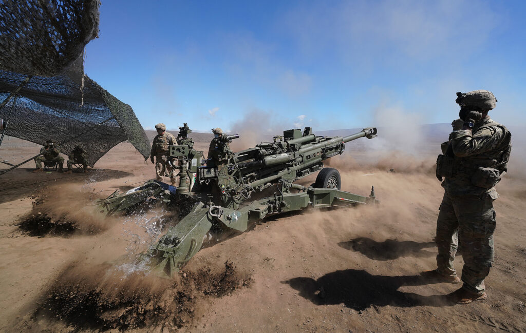 A group of soldiers on a military vehicle

Description automatically generated