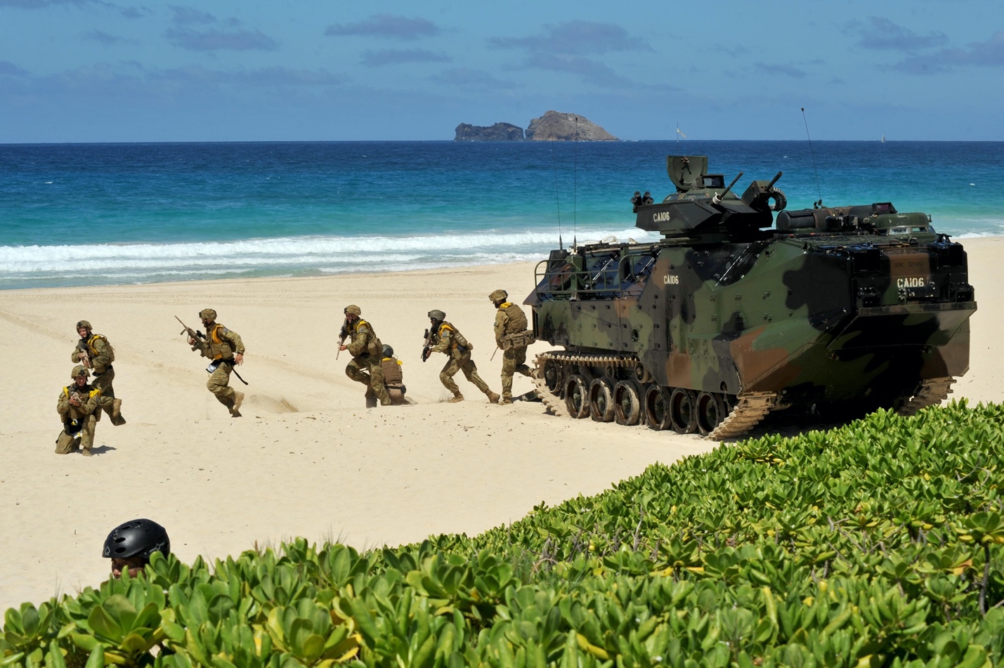 A group of soldiers running on a beach with Tulum in the background

Description automatically generated