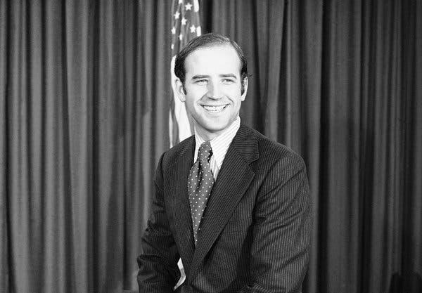 A person in a suit smiling
Description automatically generated