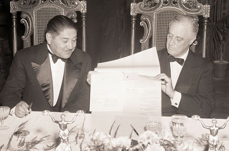 A person in tuxedo reading a piece of paper

Description automatically generated