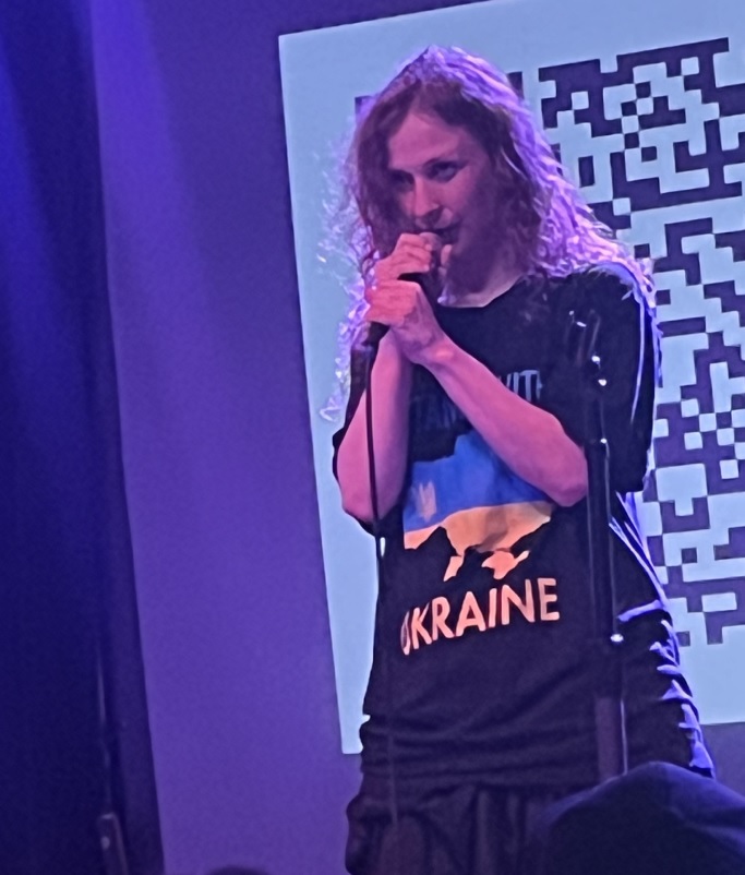 A person singing into a microphone Description automatically generated