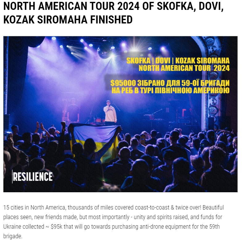 A person standing on a stage with a crowd of people
Description automatically generated