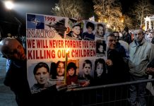 Declassified: BBC and MI6 Kosovo War Propaganda Blitz People holding a sign with pictures of children Description automatically generated