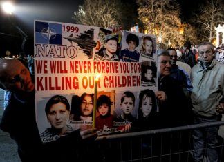 Declassified: BBC and MI6 Kosovo War Propaganda Blitz People holding a sign with pictures of children Description automatically generated