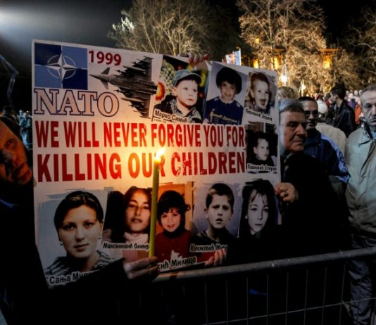 Declassified: BBC and MI6 Kosovo War Propaganda Blitz People holding a sign with pictures of children Description automatically generated