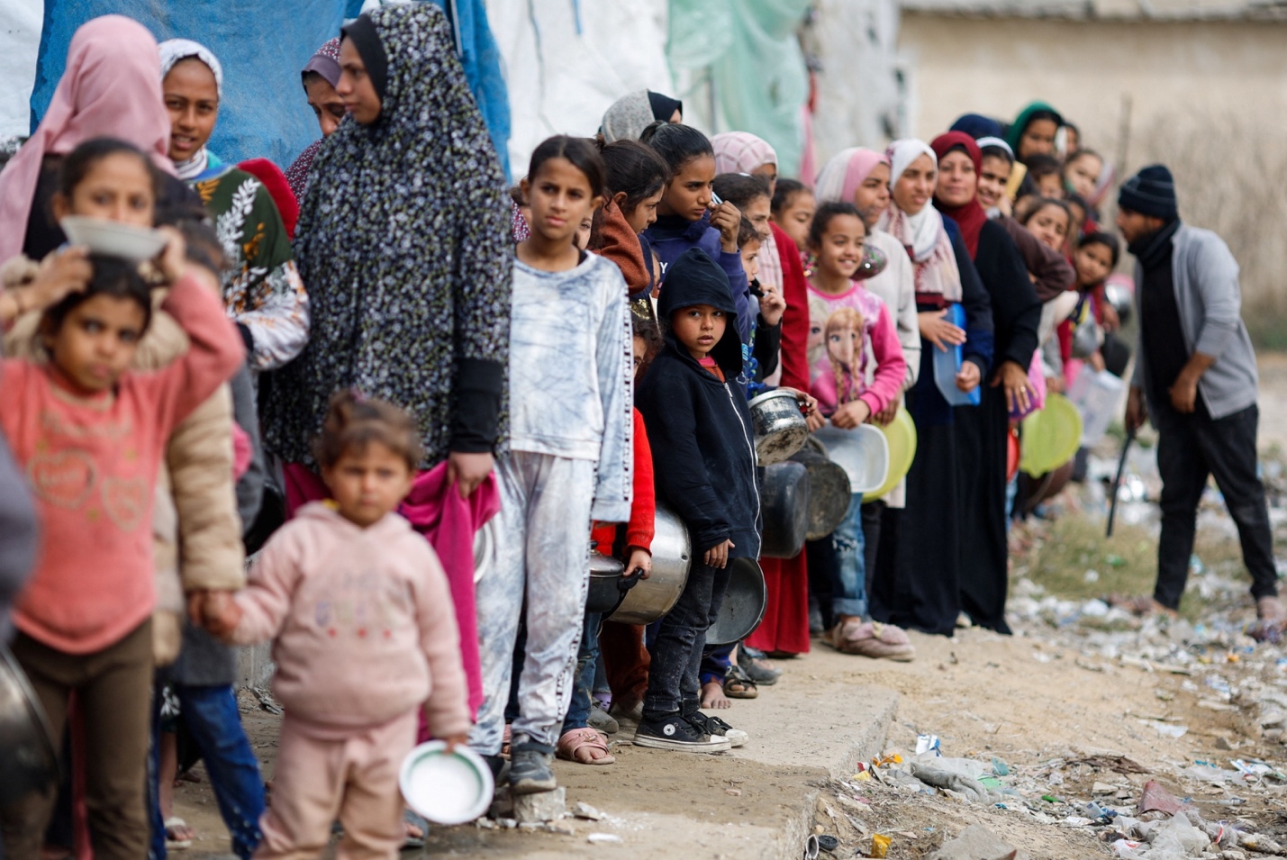 PHOTO: Palestinians stand in a line as they wait to receive food amid shortages of food supplies, Jan. 17, 2024, in Rafah in the southern Gaza Strip.