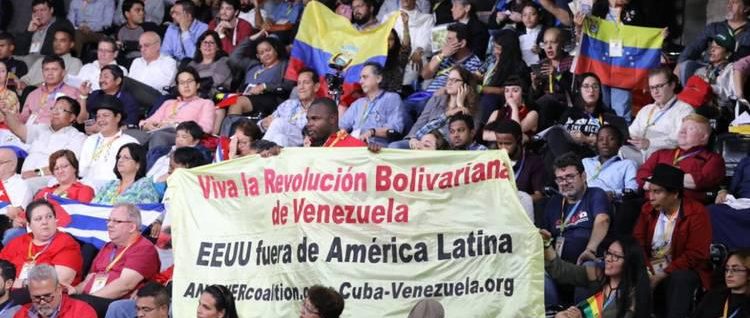 A crowd of people holding a banner

Description automatically generated