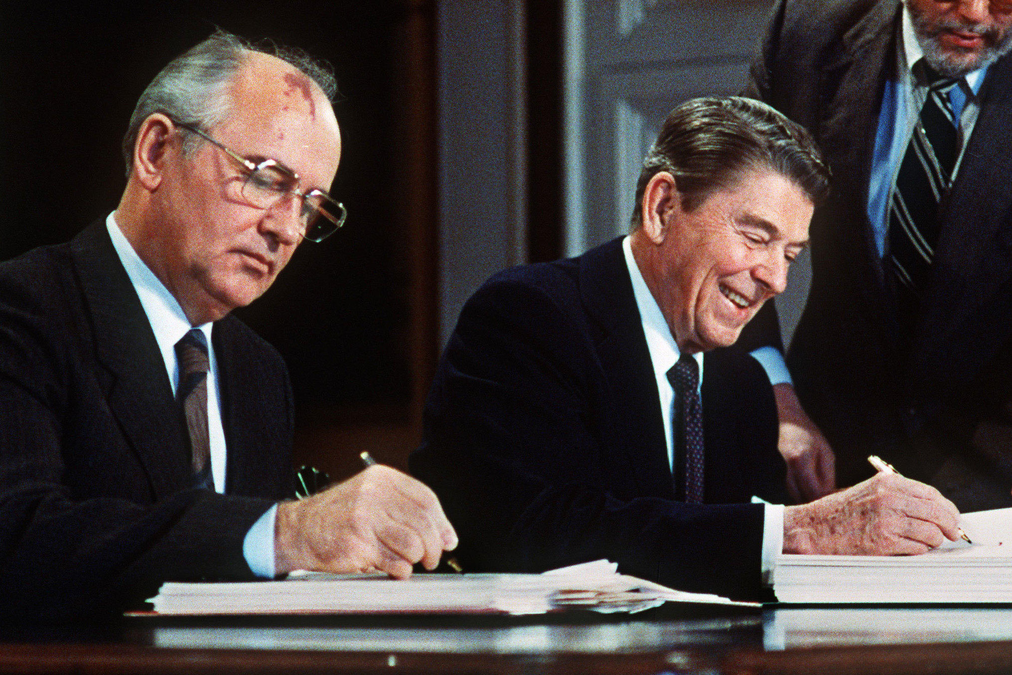 A few men signing papers

Description automatically generated