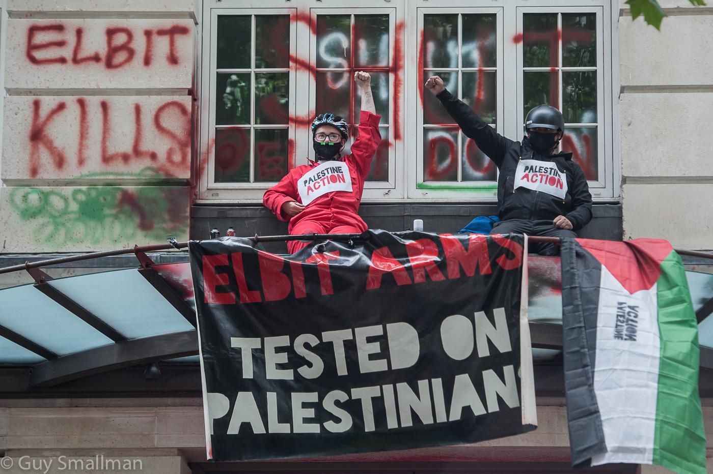 A group of people on a balcony with a sign

Description automatically generated