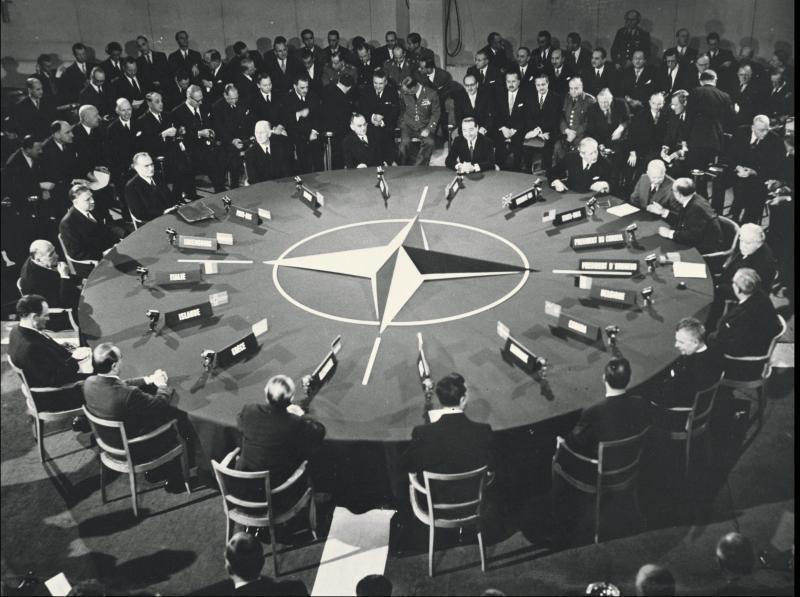 A group of people sitting around a round table

Description automatically generated