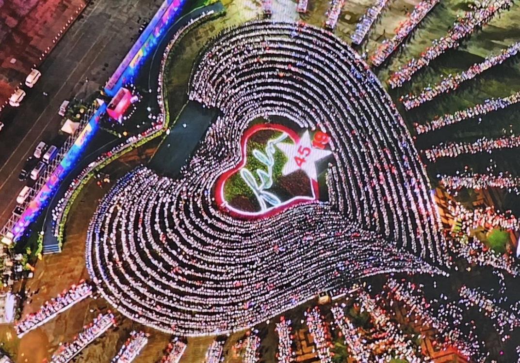 A large crowd of people in a heart shape

Description automatically generated