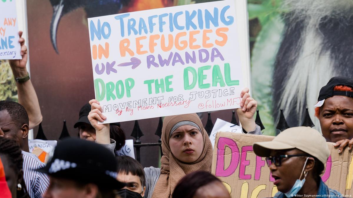 A person holding a sign

Description automatically generated