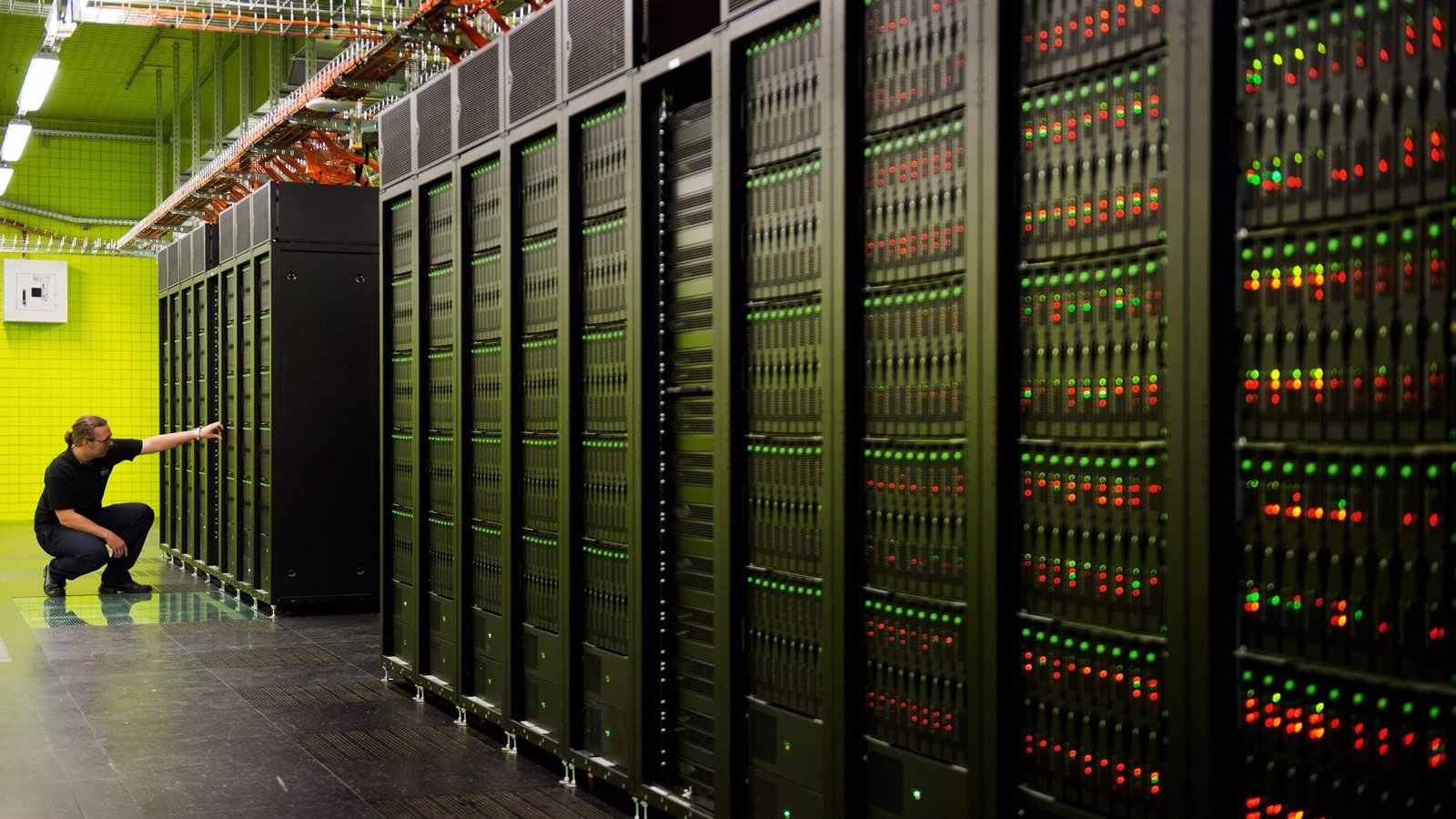 A person standing in a room with a computer server

Description automatically generated