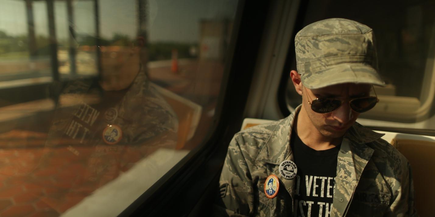 A person wearing a camouflage hat and sunglasses

Description automatically generated