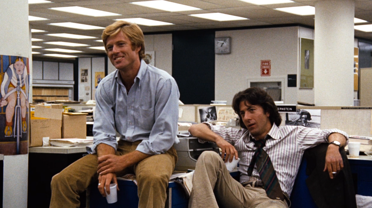 A couple of men sitting in an office

Description automatically generated