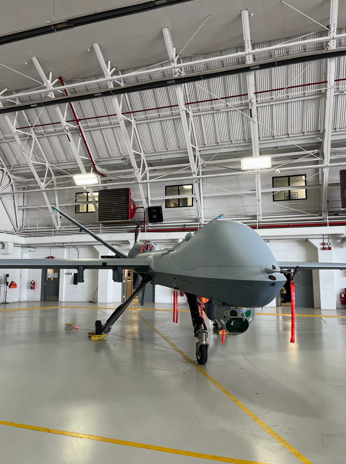 A grey airplane in a hangar

Description automatically generated