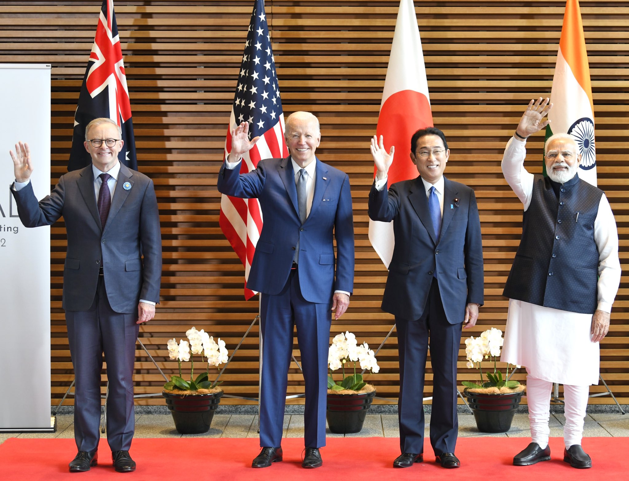 A group of men in suits waving

Description automatically generated