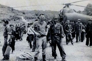 A group of men standing in front of a helicopter

Description automatically generated with medium confidence
