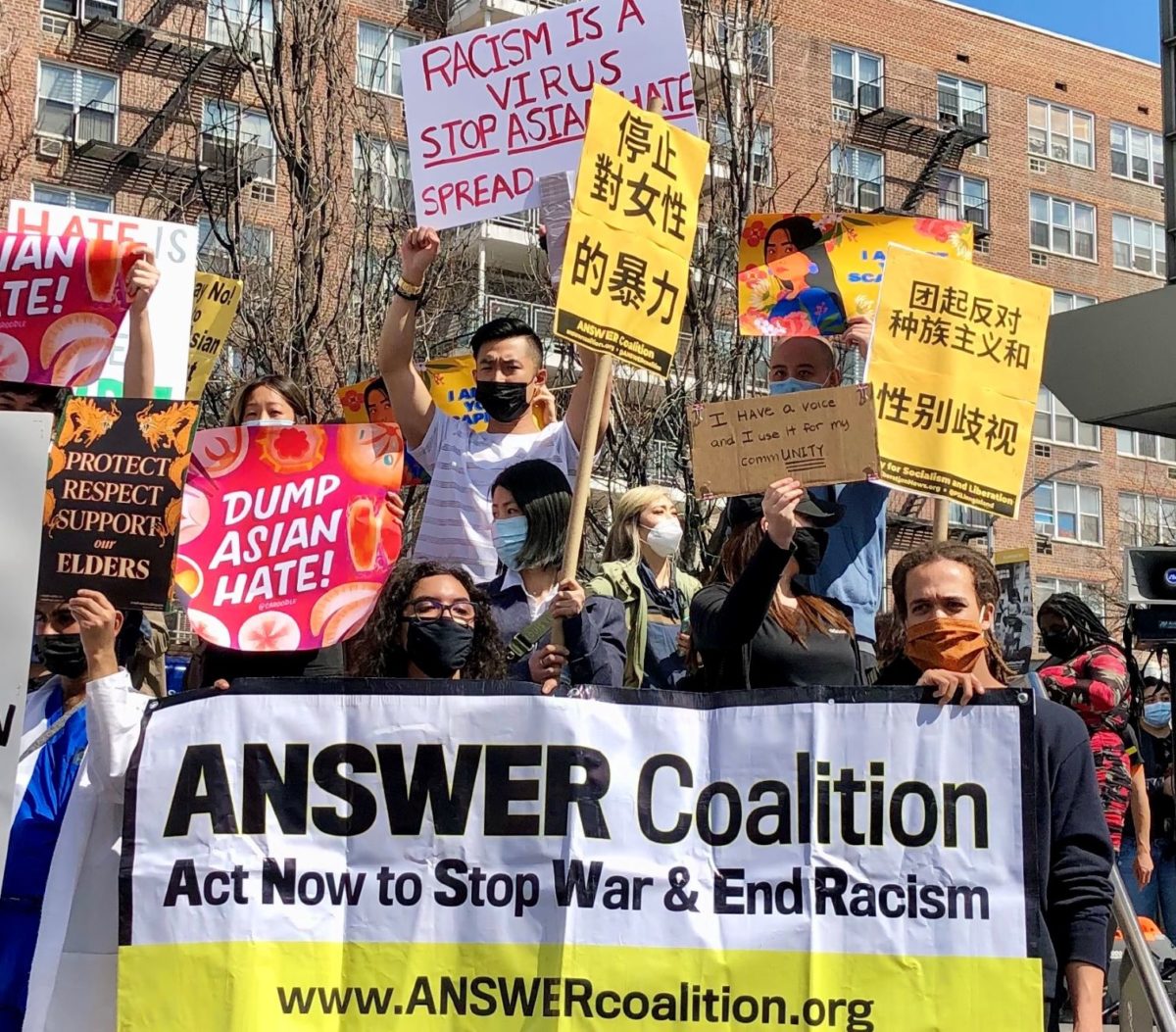 A group of people holding signs
Description automatically generated