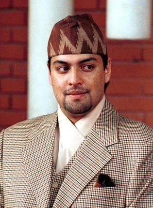 A person in a suit and hat

Description automatically generated