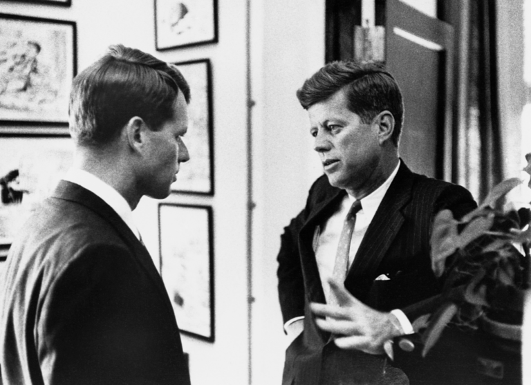 A couple of men in suits talking

Description automatically generated