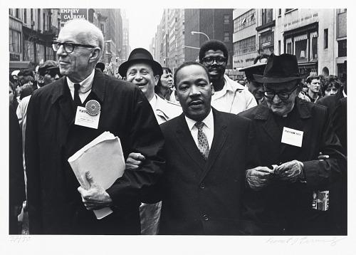 A group of men walking in a street

Description automatically generated
