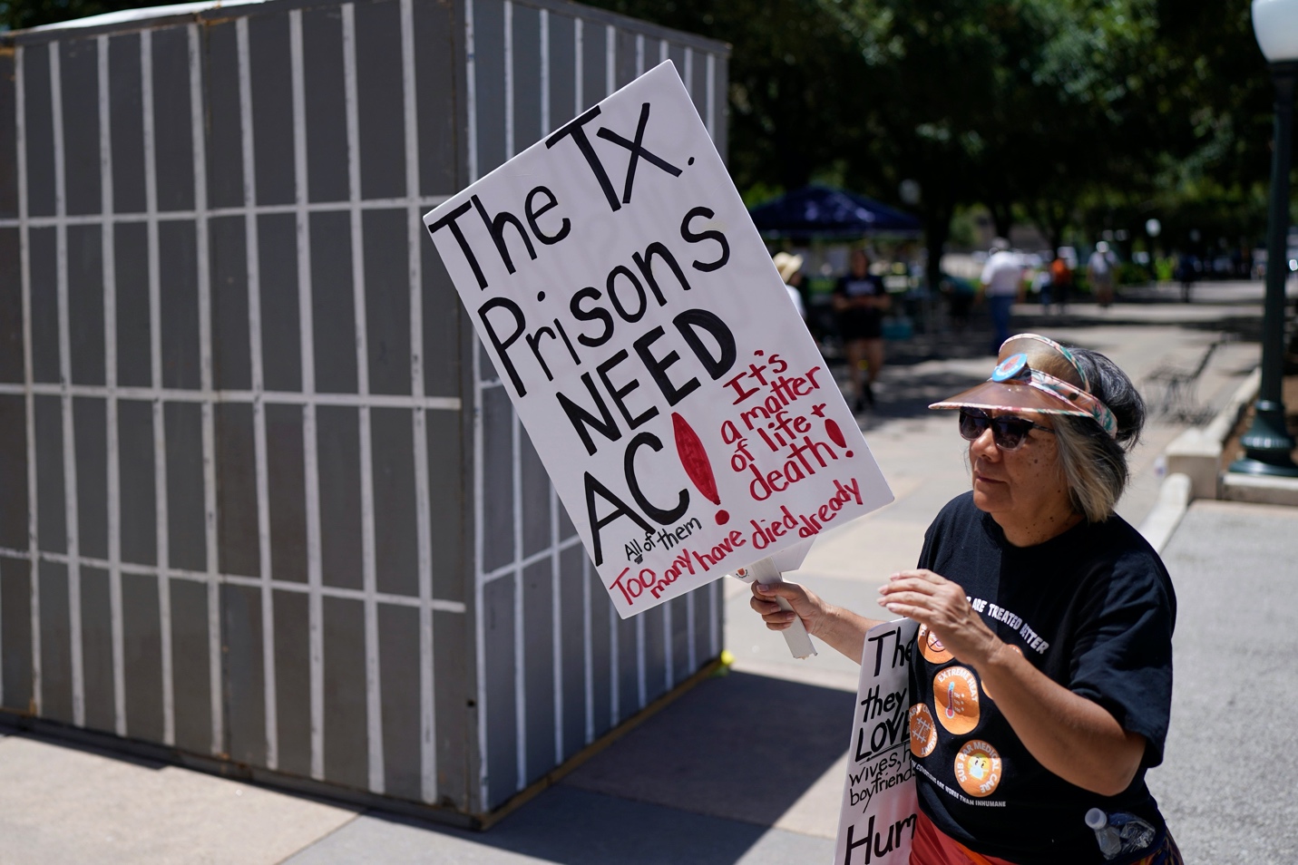 A person holding a sign

Description automatically generated