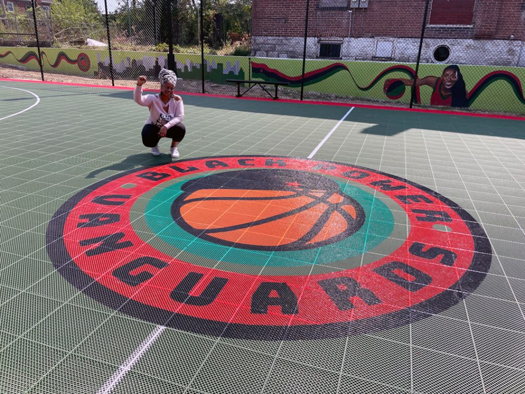 A person kneeling on a basketball court

Description automatically generated