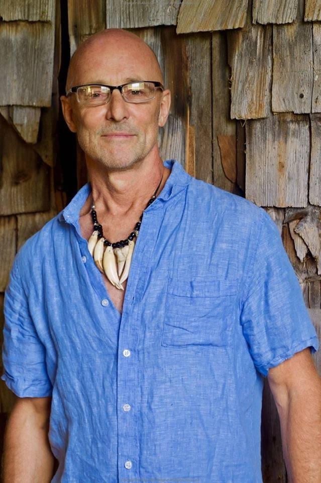 A person wearing a blue shirt and a necklace

Description automatically generated