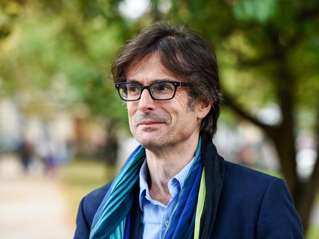 A person wearing glasses and a blue scarf

Description automatically generated