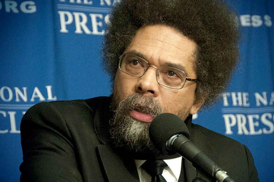 A person with a beard and glasses speaking into a microphone

Description automatically generated