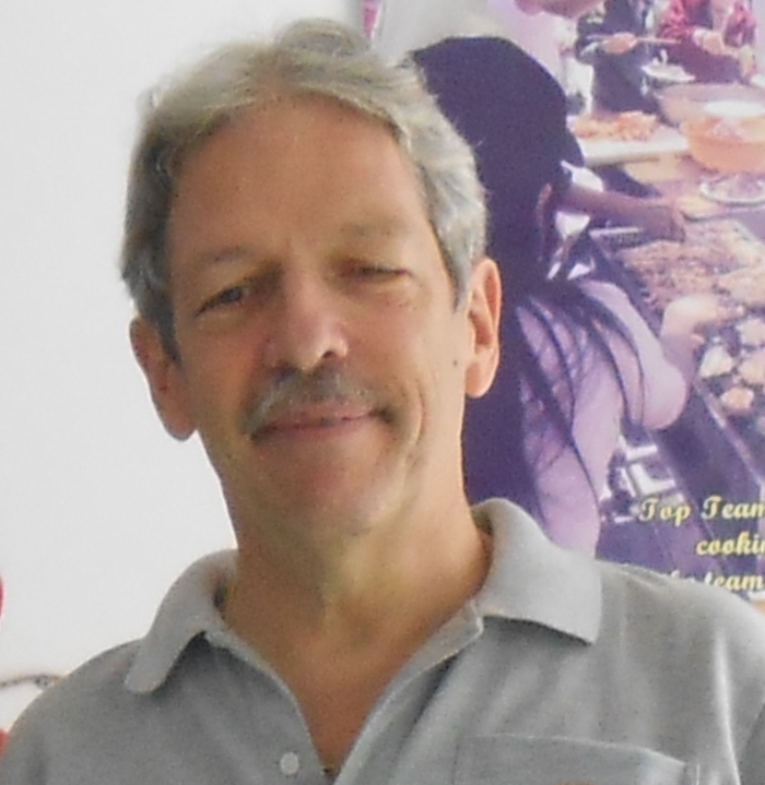 A person with grey hair and mustache
Description automatically generated