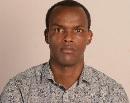 A person with short hair wearing a patterned shirt

Description automatically generated