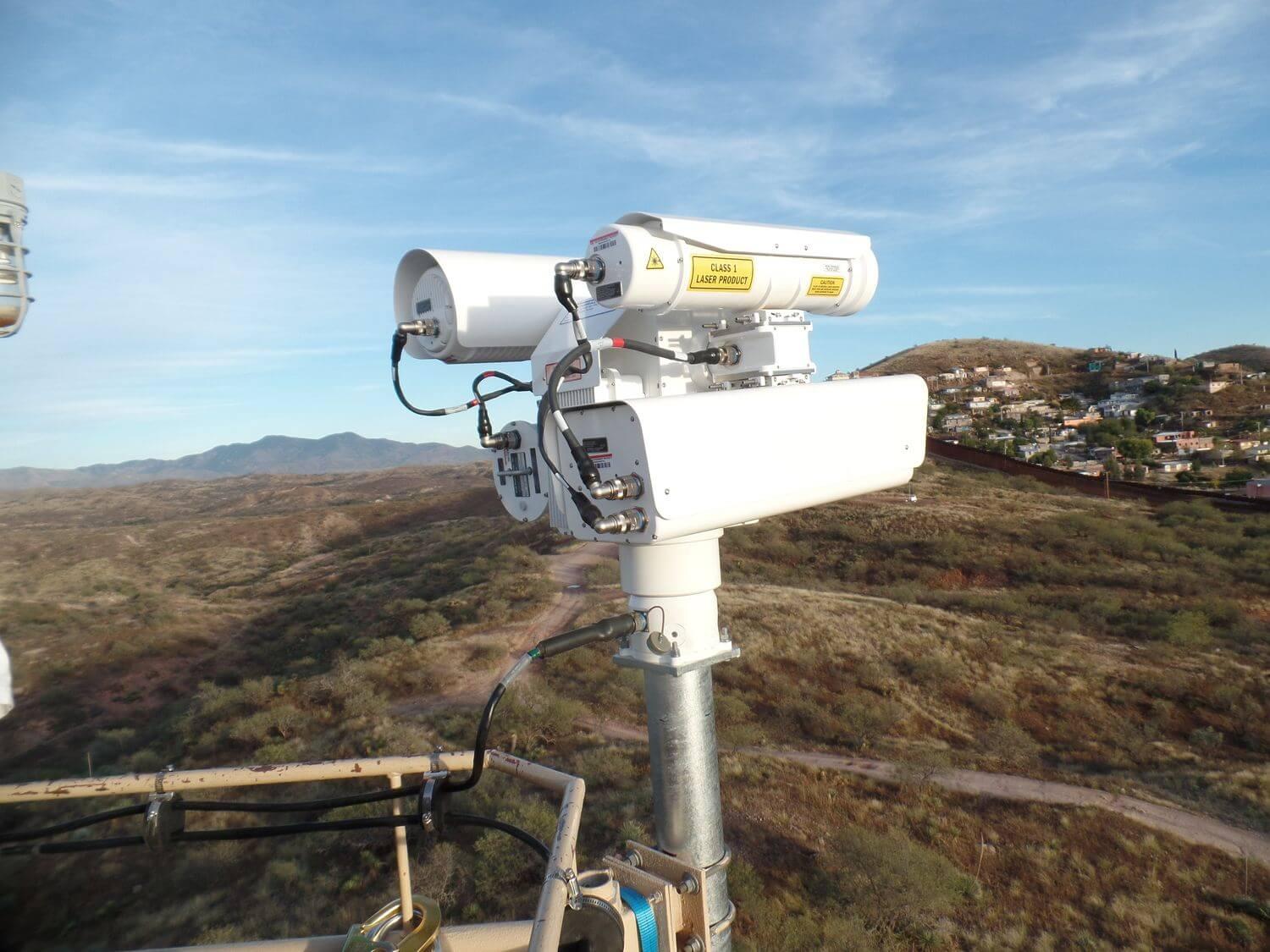 A white camera on a pole
Description automatically generated