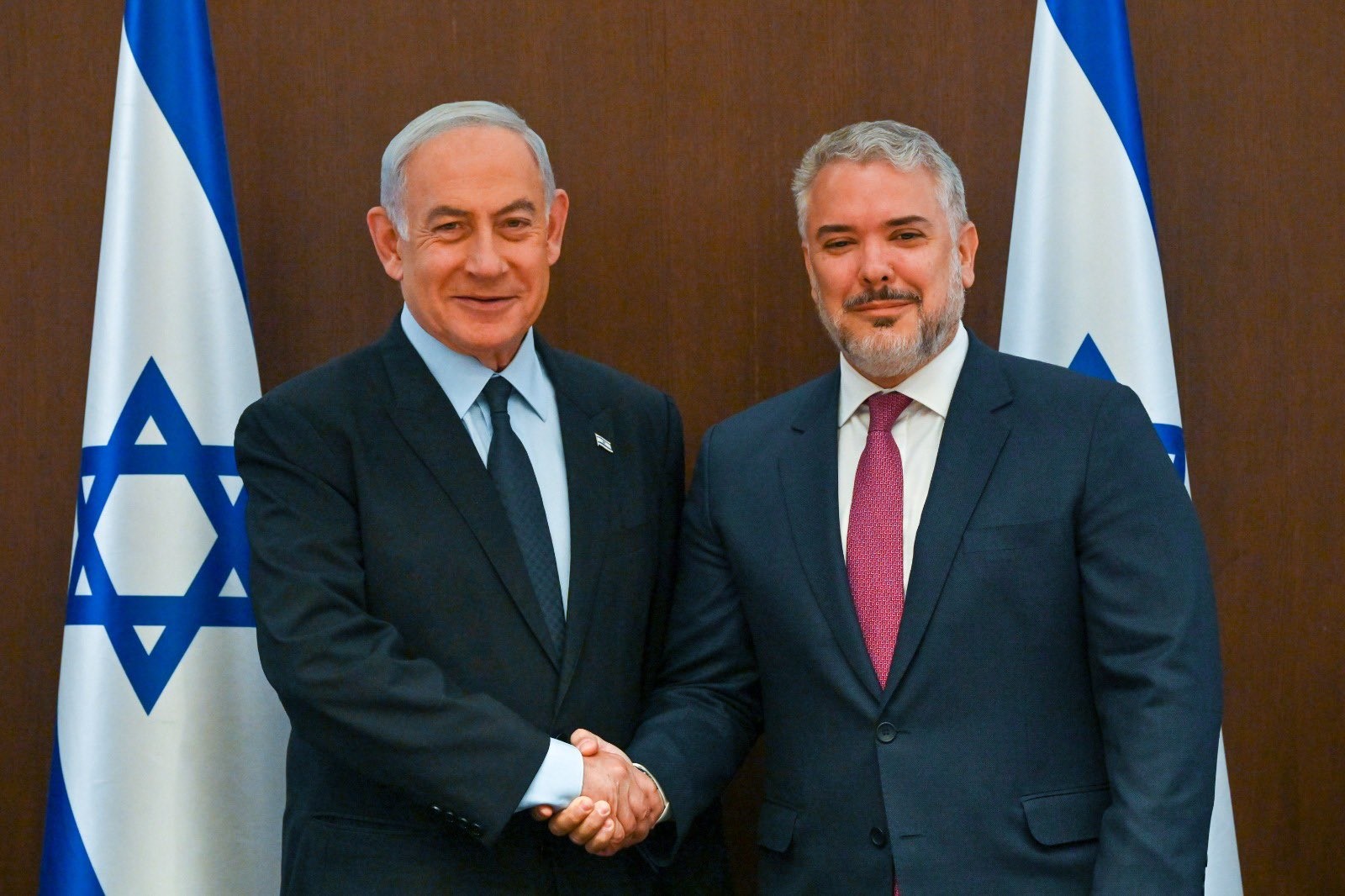 A couple of men shaking hands

Description automatically generated