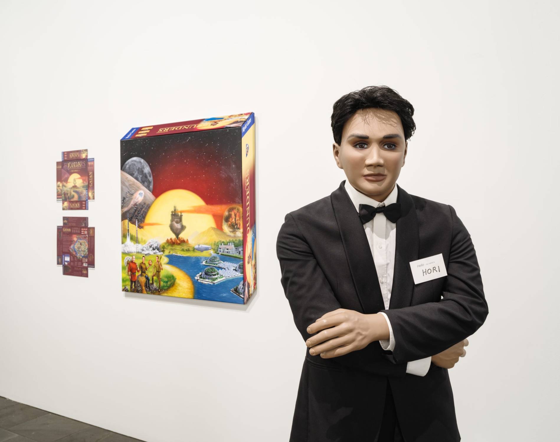 A mannequin in a tuxedo next to a board game
Description automatically generated