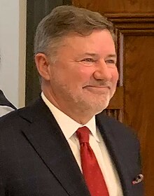 A person in a suit and tie
Description automatically generated