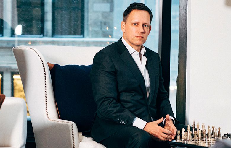 A person in a suit sitting on a couch
Description automatically generated