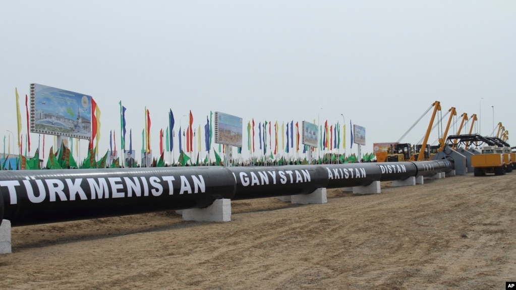 FILE - Workers at the Turkmen-Afghan border prepare to weld the first link crossing the frontier during the integration ceremony of the pipeline in Serhetabat, Turkmenistan, Feb. 23, 2018.