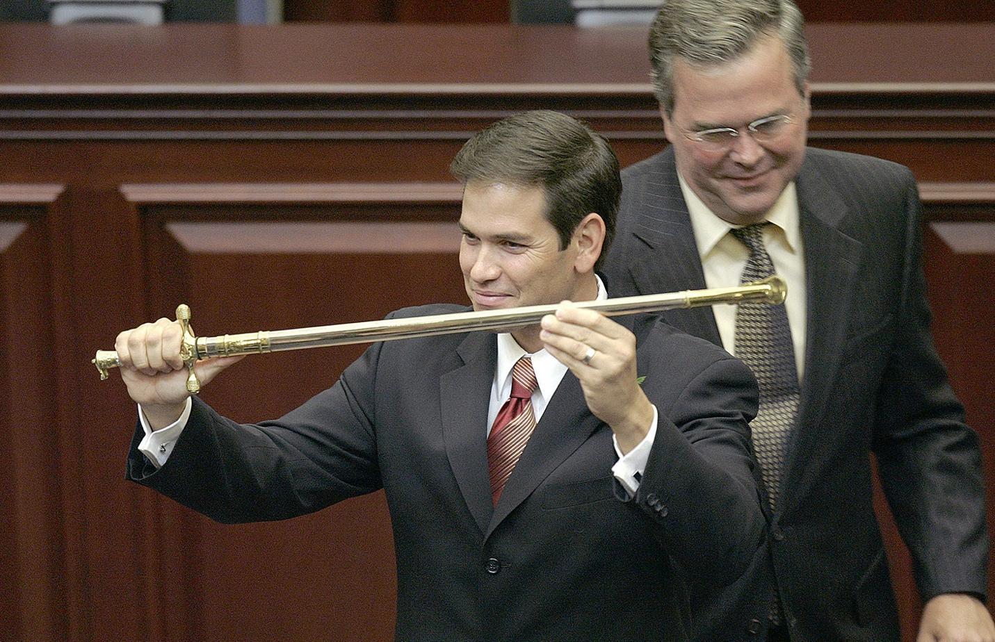 A group of men in suits holding a sword

Description automatically generated