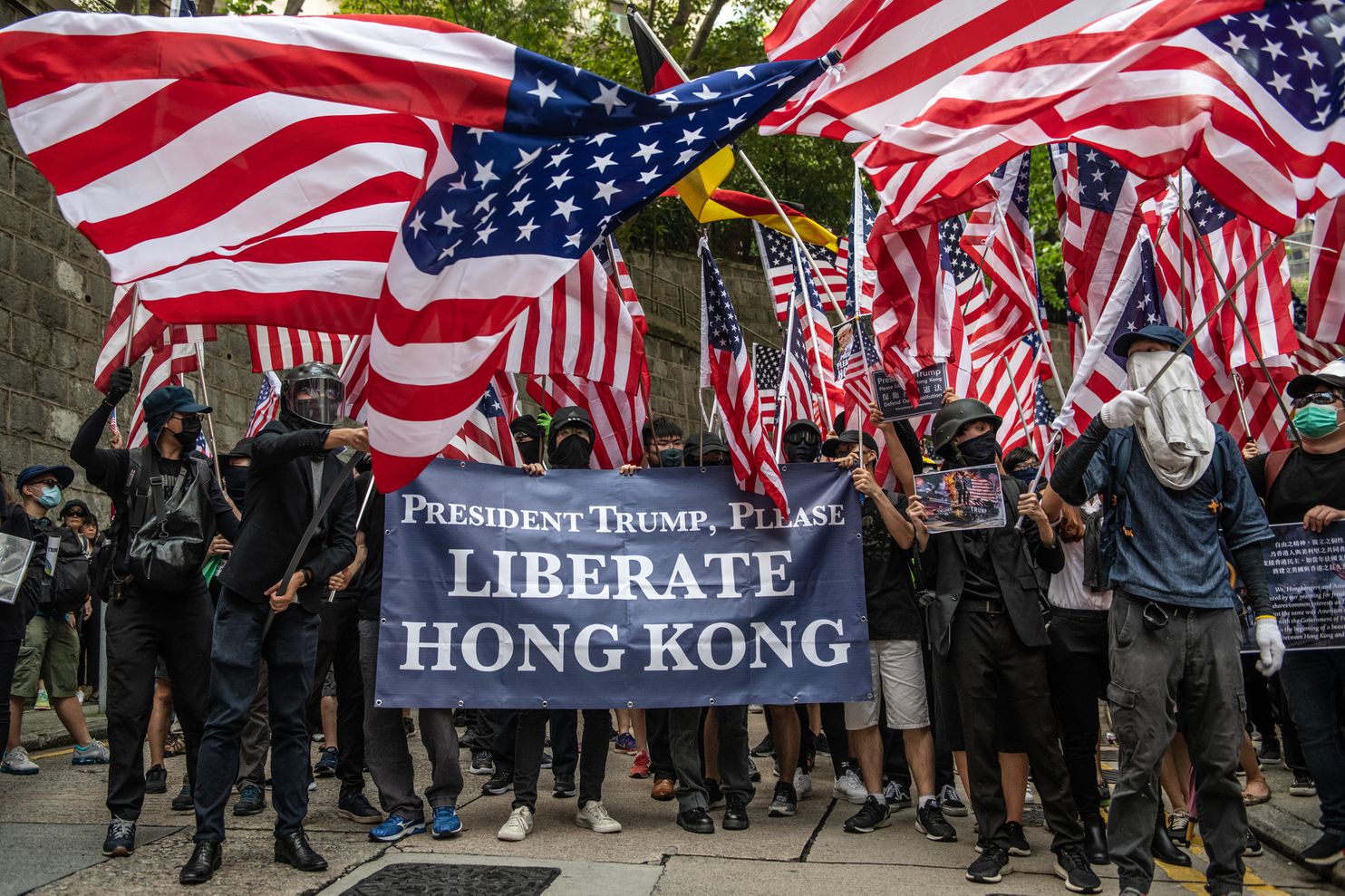 A group of people holding flags

Description automatically generated